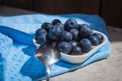 早....新鲜的早餐新鲜的蓝莓蓝莓白色飞碟蓝色的背景