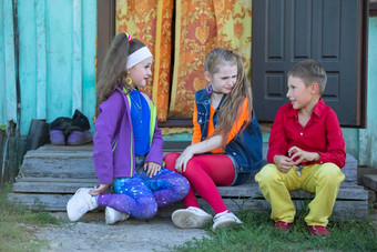 有趣的孩子们女孩明亮的化妆穿着风格年代男孩红色的衬衫坐着村玄关房子俄罗斯村孩子们