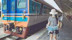 年轻的女旅游穿面具走火车站旅游地图旅行信息概念正常的旅行旅游