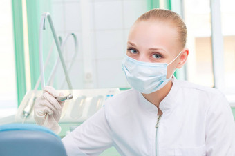 女牙医保护面具持有牙科钻