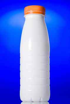 白色牛奶瓶孤立的蓝色的