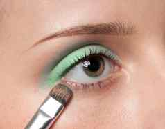 女人应用化妆品油漆刷眼睛区
