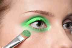 女人应用化妆品油漆刷眼睛区