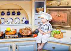 男孩坐在厨房表格戏剧烹饪