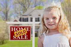 可爱的女孩院子里出售出售真正的房地产标志房子