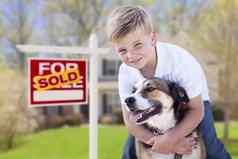 年轻的男孩狗前面出售出售标志房子