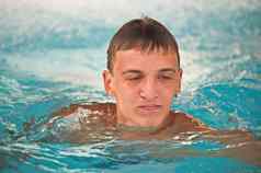 快乐青少年男孩蓝色的游泳池肖像