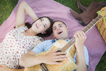 混合比赛夫妇公园玩吉他唱歌