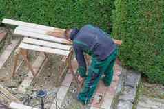 男人。中风保护油漆木花园家具