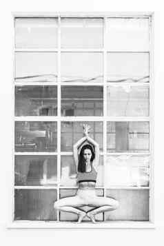 适合运动活跃的女孩时尚运动服装瑜伽健身锻炼前面大工业窗口框架色彩斑斓的反射窗口玻璃城市风格瑜伽黑色的白色
