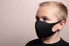 年轻的男孩穿脸面具防止传播细菌
