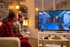 夫妇玩视频游戏大屏幕生活房间晚些时候晚上