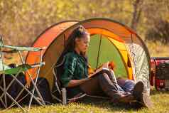 年轻的女孩阅读书前面帐篷
