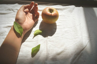 叶覆盖手腕手苹果白色床上表