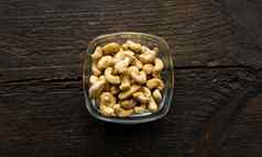 腰果坚果小板古董木表格背景腰果螺母健康的素食者蛋白质有营养的食物