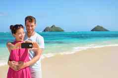海滩假期夫妇采取自拍智能手机
