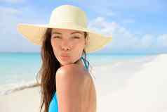 海滩太阳他女人吹可爱的吻假期亚洲女年轻的成人模型引人注目的接吻构成相机夏天假期穿稻草遮阳帽蓝色的比基尼完美的白色沙子