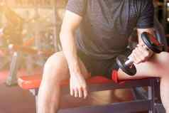 健美运动员工作哑铃权重健身健身房女健美运动员练习哑铃健身肌肉发达的身体饮食生活方式重量损失健康的概念