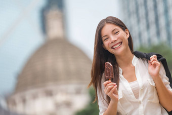业务女人吃冰奶油在香港香港年轻的女商人享受冰淇淋坚持走微笑快乐中央在香港香港混合比赛中国人亚洲高加索人模型打破