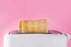 烤烤面包面包白色烤面包机粉红色的背景