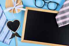 快乐父亲一天背景概念蓝色的粉红色的领带眼镜礼物盒子黑色的心形状黑板上蓝色的背景复制空间文本