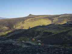 色彩斑斓的帐篷机器人山小屋冰岛洛加徒步旅行小道绿色谷火山景观熔岩字段早期早....日出视图