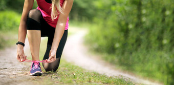 年轻的健身女人系鞋带运行<strong>运动</strong>鞋健康的适合生活
