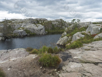 视图小水池塘湖徒步旅行<strong>讲坛</strong>岩巨大的悬崖著名的挪威的观点喜怒无常的天空秋天一天自然旅行背景假期徒步旅行假期概念