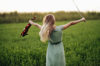 快乐音乐家小提琴家持有小提琴手日落光