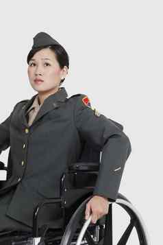 女军事官轮椅灰色的背景