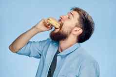 男人。汉堡手零食食物快食物蓝色的衬衫领带
