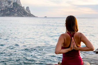 有吸引力的女人实践瑜伽海滩日落日出vedra伊比沙岛西班牙