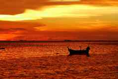 日落红色的橙色黄色的云天空钓鱼船