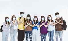 年轻的学生集团穿保护医疗脸面具站手势