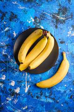 香蕉水果黑色的板蓝色的变形背景前视图