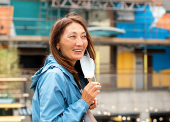 亚洲女人穿脸面具走城市微笑