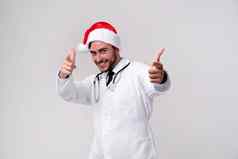 年轻的英俊的医生白色制服圣诞老人老人他站工作室白色背景微笑手指相机