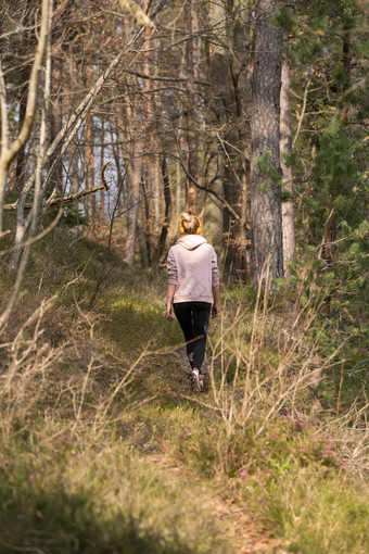 后视图活跃的运动女人听音乐运行秋天秋天森林女跑步者培训户外健康的生活方式图像年轻的高加索人女人慢跑