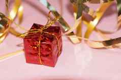 闪亮的红色的礼物盒子黄金丝带粉红色的背景