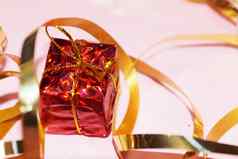 闪亮的红色的礼物盒子黄金丝带粉红色的背景