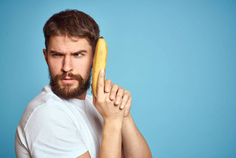 男人。香蕉抓住了白色t恤蓝色的背景概念沟<strong>通电</strong>话