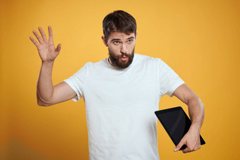 男人。平板电脑黄色的背景白色t恤技术商人触摸屏幕触控板
