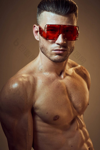 运动男人。膨胀的肌肉发达的身体穿黑暗时尚眼镜