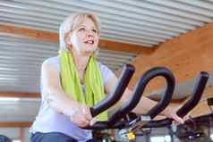 高级女人锻炼自行车健身房