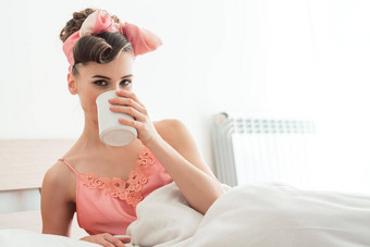 美丽的女人喝着早....咖啡床上