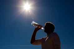 男人。喝瓶装水太阳