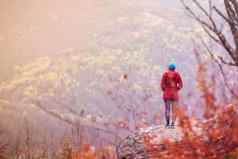 徒步旅行女孩波兰人背包站岩石多风的秋天一天旅行健康的生活方式在户外秋天季节