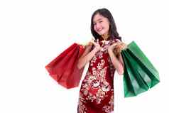 年轻的亚洲美女人穿旗袍持有红色的绿色购物袋手势中国人一年节日事件孤立的白色背景假期生活方式概念旗袍衣服