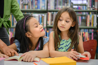 可爱的女孩嫉妒阅读书图书馆老师教学人生活方式教育年轻的友谊孩子们的关系学校概念托儿所主题