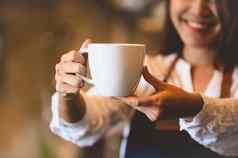特写镜头白色咖啡杯美丽的亚洲女人咖啡师背景服务客户工作占领食物喝饮料咖啡商店咖啡馆业务餐厅所有权